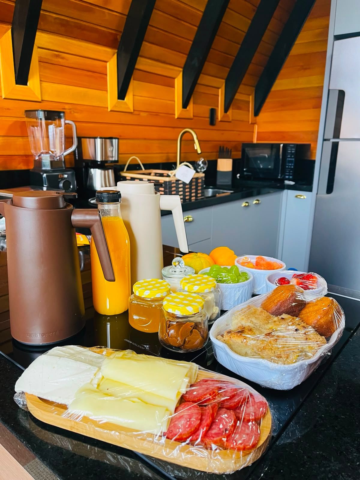 Café da manhã colonial com frios, queijos, pães, sucos e frutas