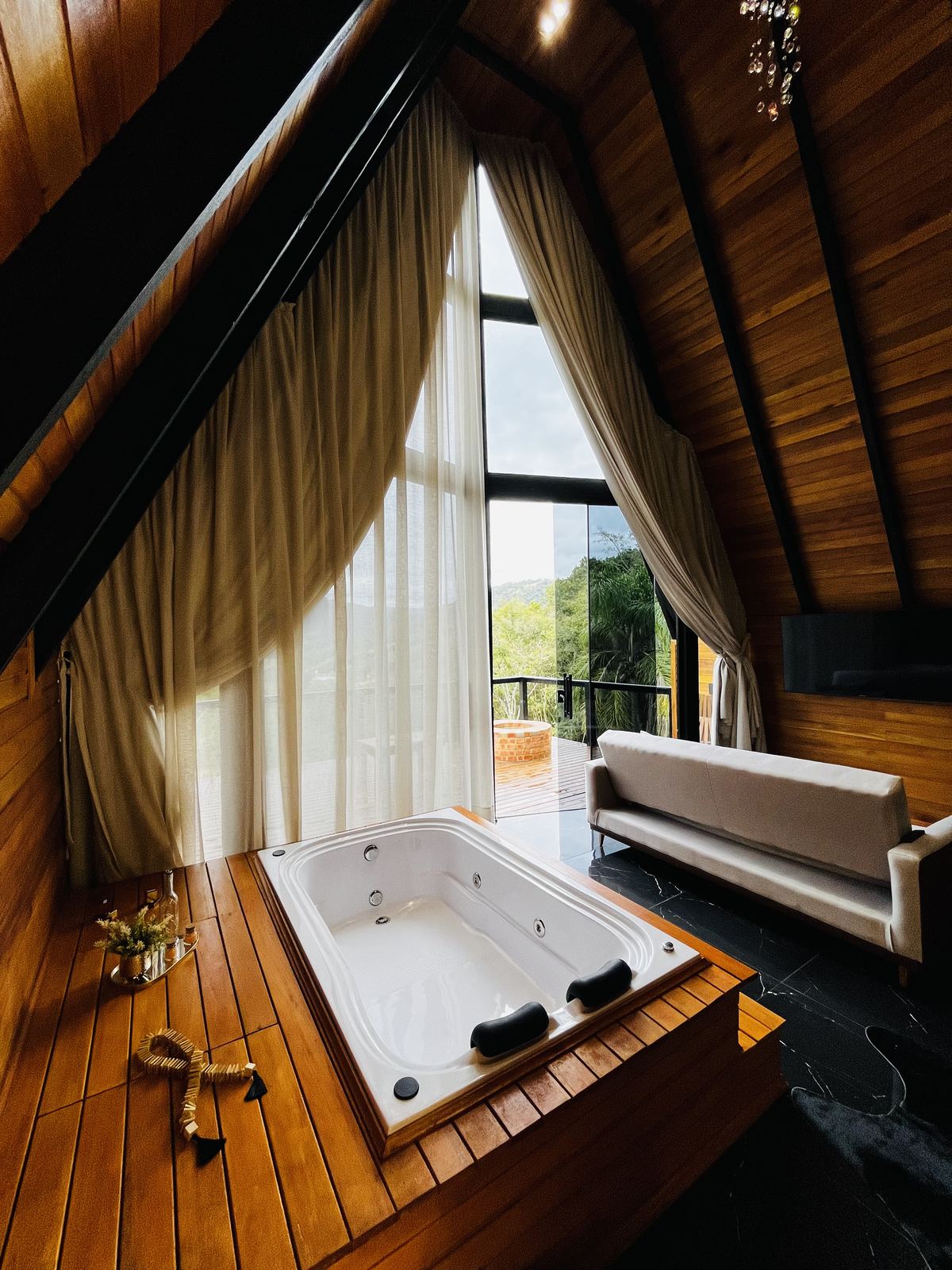 Hidromassagem com sofá ao fundo e vista para a Serra Catarinense